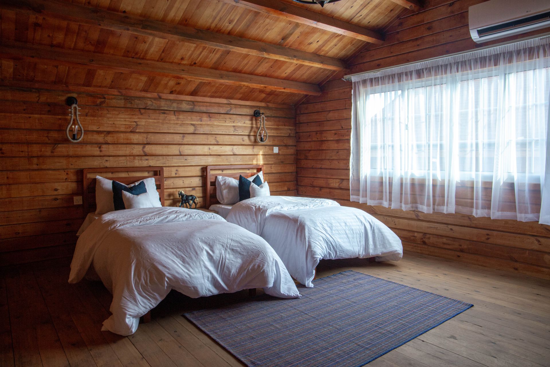 Camera tripla in legno con due letti e luce naturale